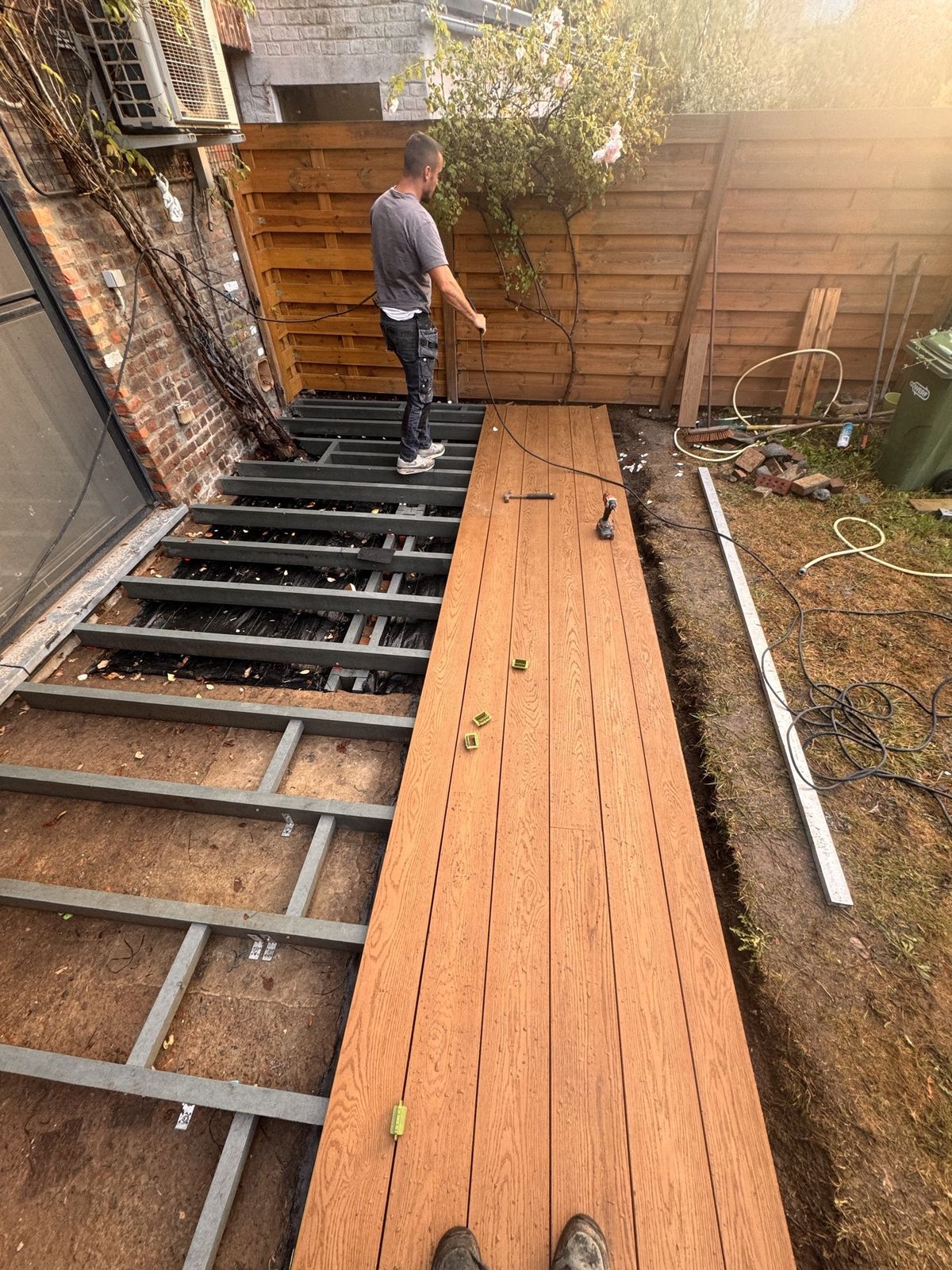 Onze vakman legt de Millboard-planken op de draagstructuur